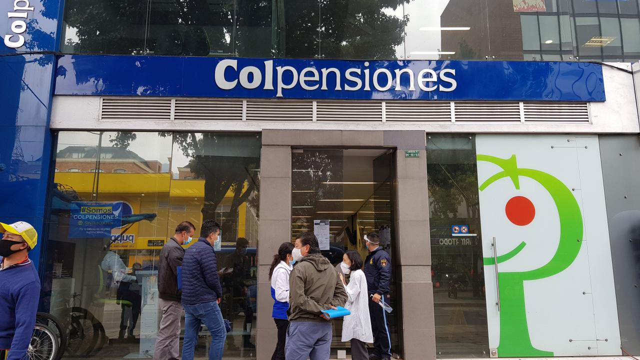 Personas esperan frente a una oficina del fondo de pensiones estatal Colpensiones en Bogotá, Colombia.