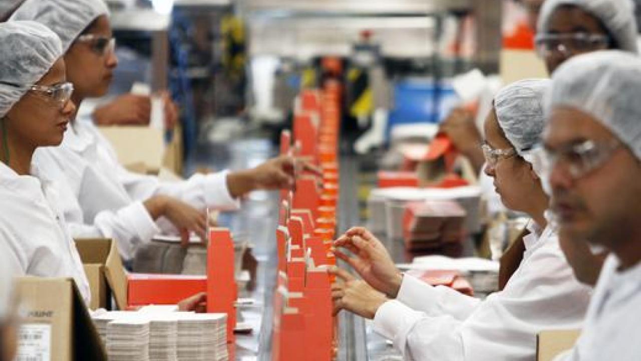 Workers pack cosmetic products into boxes at Natura's factory in Cajamar, Sao Paulo.