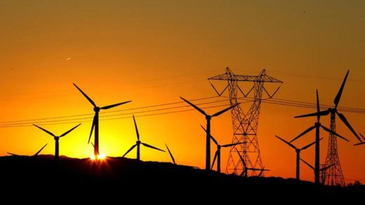 The sun rises behind windmills at a wind farm in Palm Springs, California.