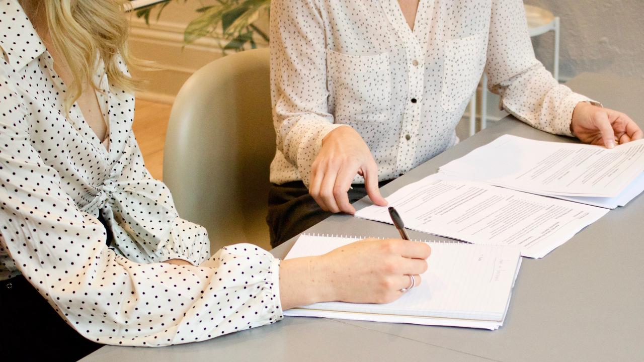 Dos mujeres firmando contratos.