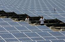 Cecilio Sumaoy (izq.), director de planta de Cagayan Electric Power and Light Co. Inc. (CEPALCO), pasa por delante de un conjunto de paneles solares de dos hectáreas instalado en el pueblo de Indahag, en Cagayan De Oro, al sur de Filipinas.