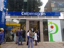 Personas esperan frente a una oficina del fondo de pensiones estatal Colpensiones en Bogotá, Colombia.