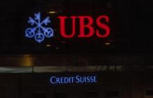 Logos of Swiss banks UBS and Credit Suisse are seen on an office building in Zurich, Switzerland.