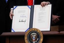 U.S. President Donald Trump shows off the United States-Mexico-Canada Trade Agreement (USMCA) after signing it on the South Lawn of the White House in Washington, U.S., January 29, 2020.