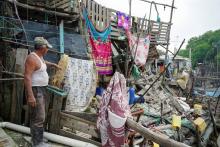 A man points at a damaged house following an earthquake in Isla Puna, Ecuador.