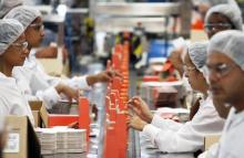 Workers pack cosmetic products into boxes at Natura's factory in Cajamar, Sao Paulo.