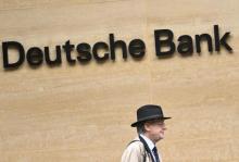 Hombre caminando frente a logo de Deutsche Bank